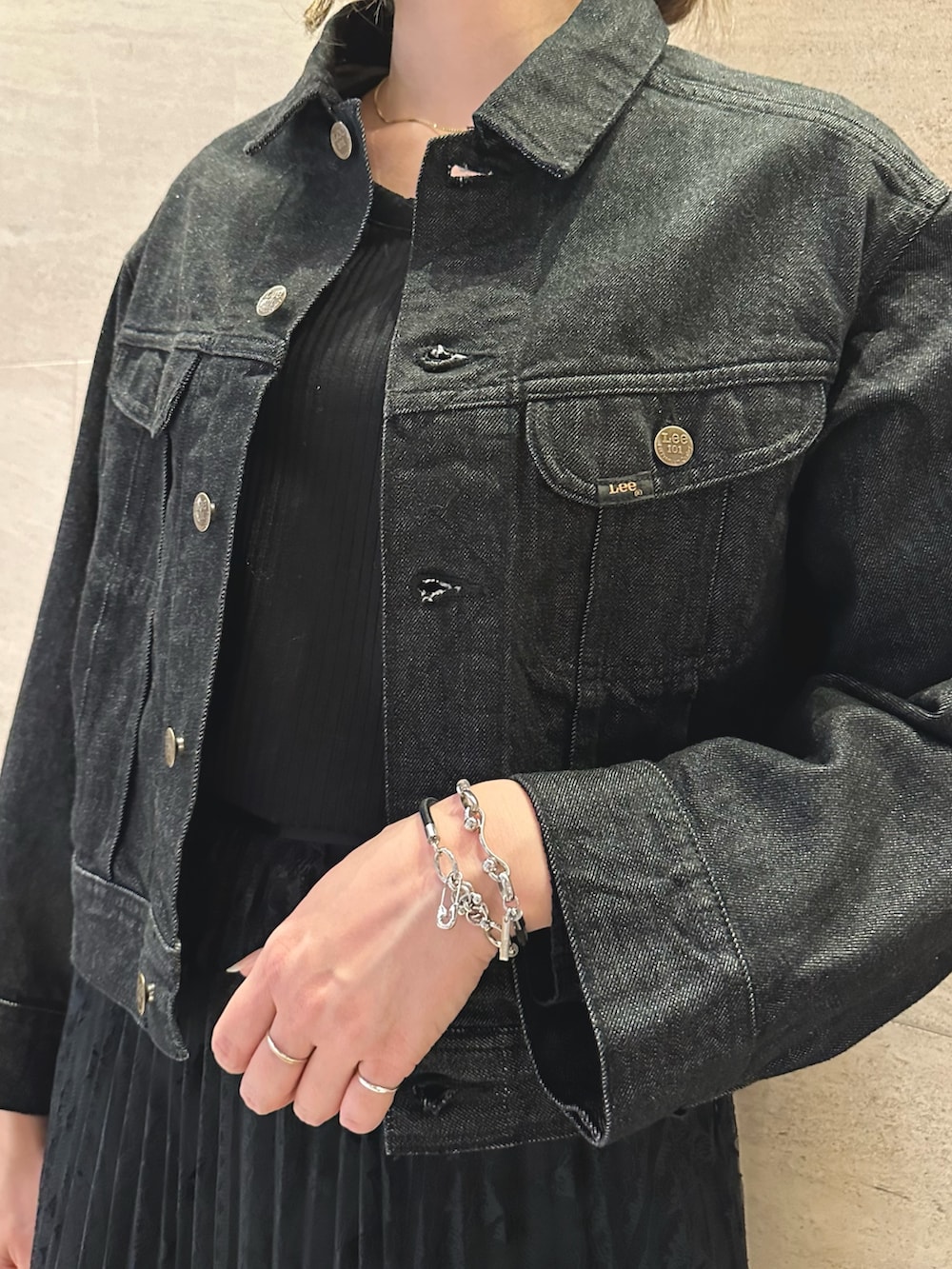 ブラック系のデニムジャケット、ホワイト系のTシャツ/カットソー、ブラック系のスカートを着用したレディースの秋コーディネートの6枚目の写真