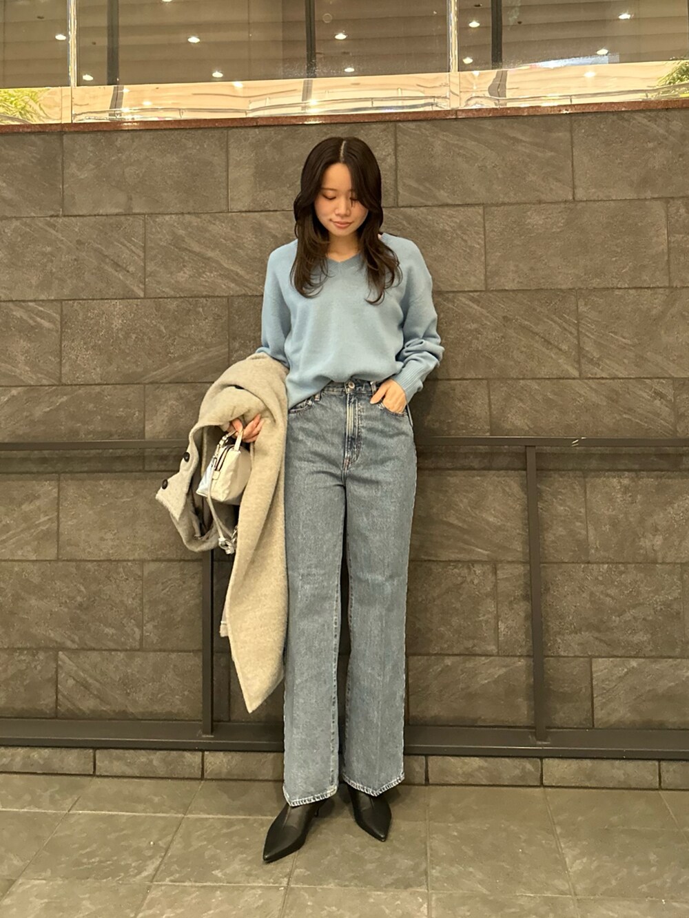グレー系のその他アウター、ブルー系のニット/セーター、ブルー系のデニムパンツを着用したレディースの冬コーディネートの6枚目の写真