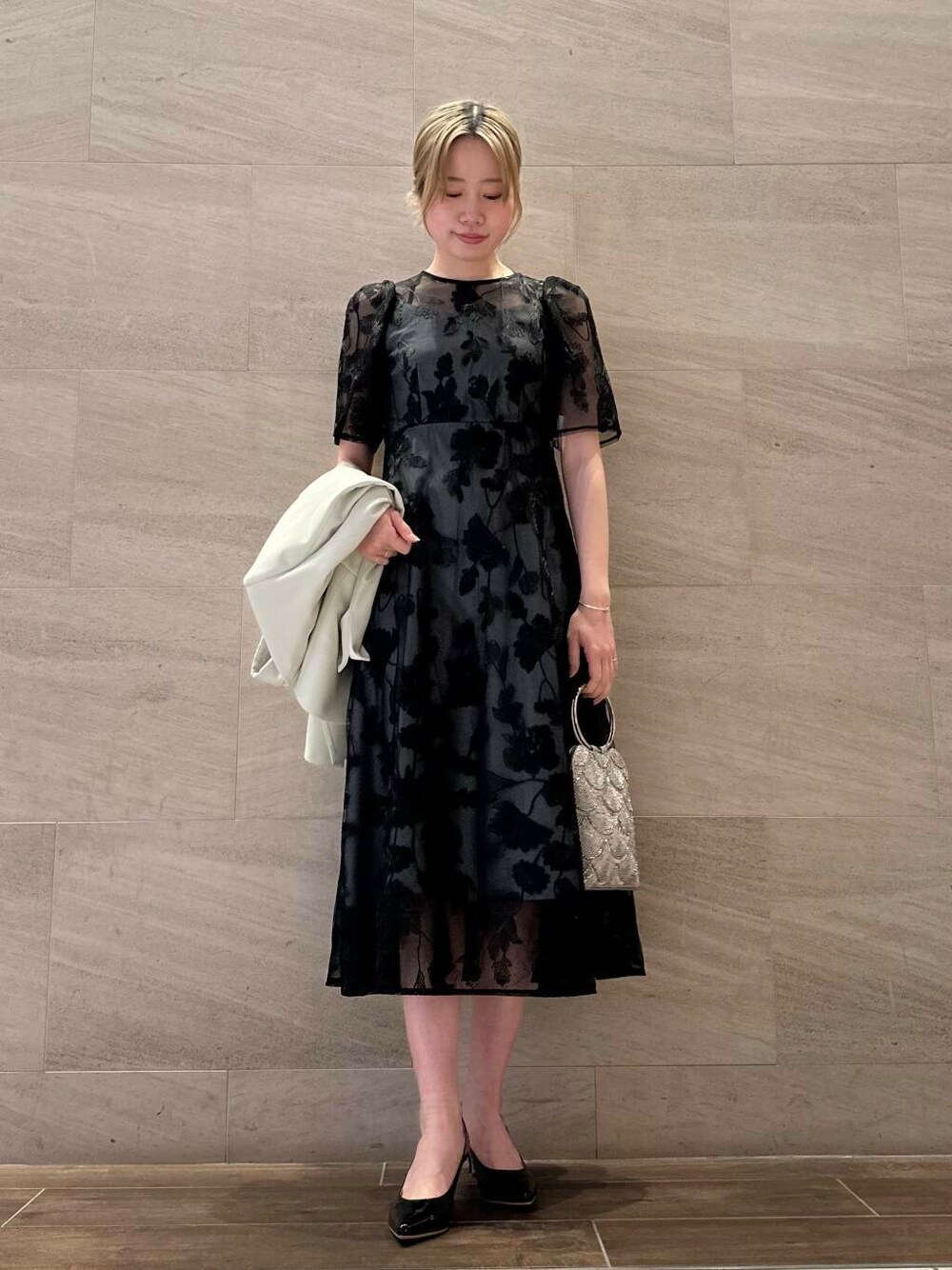 ブラック系のパンプス、シルバー系のハンドバッグ、イエロー系のその他アウターを着用したレディースの春コーディネートの4枚目の写真