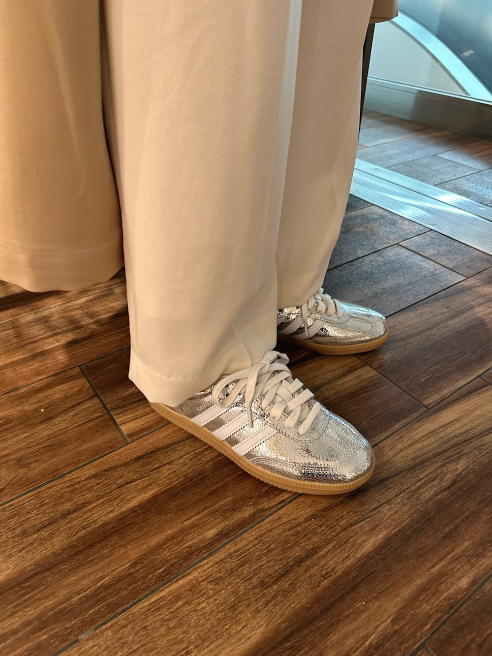 ベージュ系のトレンチコート、ホワイト系のTシャツ/カットソー、ブラック系のショルダーバッグを着用したレディースの春コーディネートの7枚目の写真