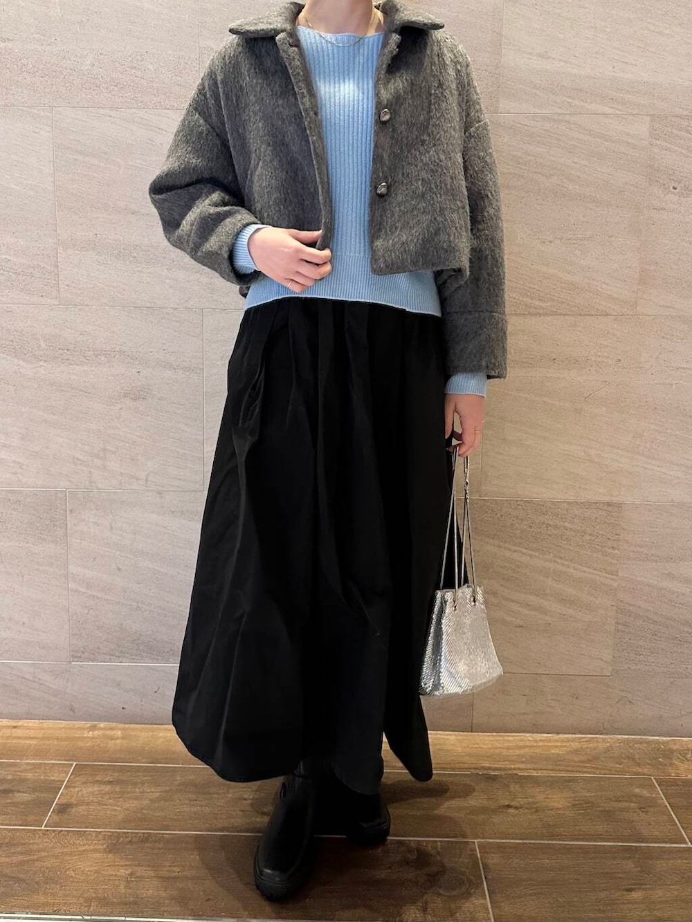 ブラック系のブーツ、グレー系のその他アウター、ブルー系のニット/セーターを着用したレディースの冬コーディネートの4枚目の写真