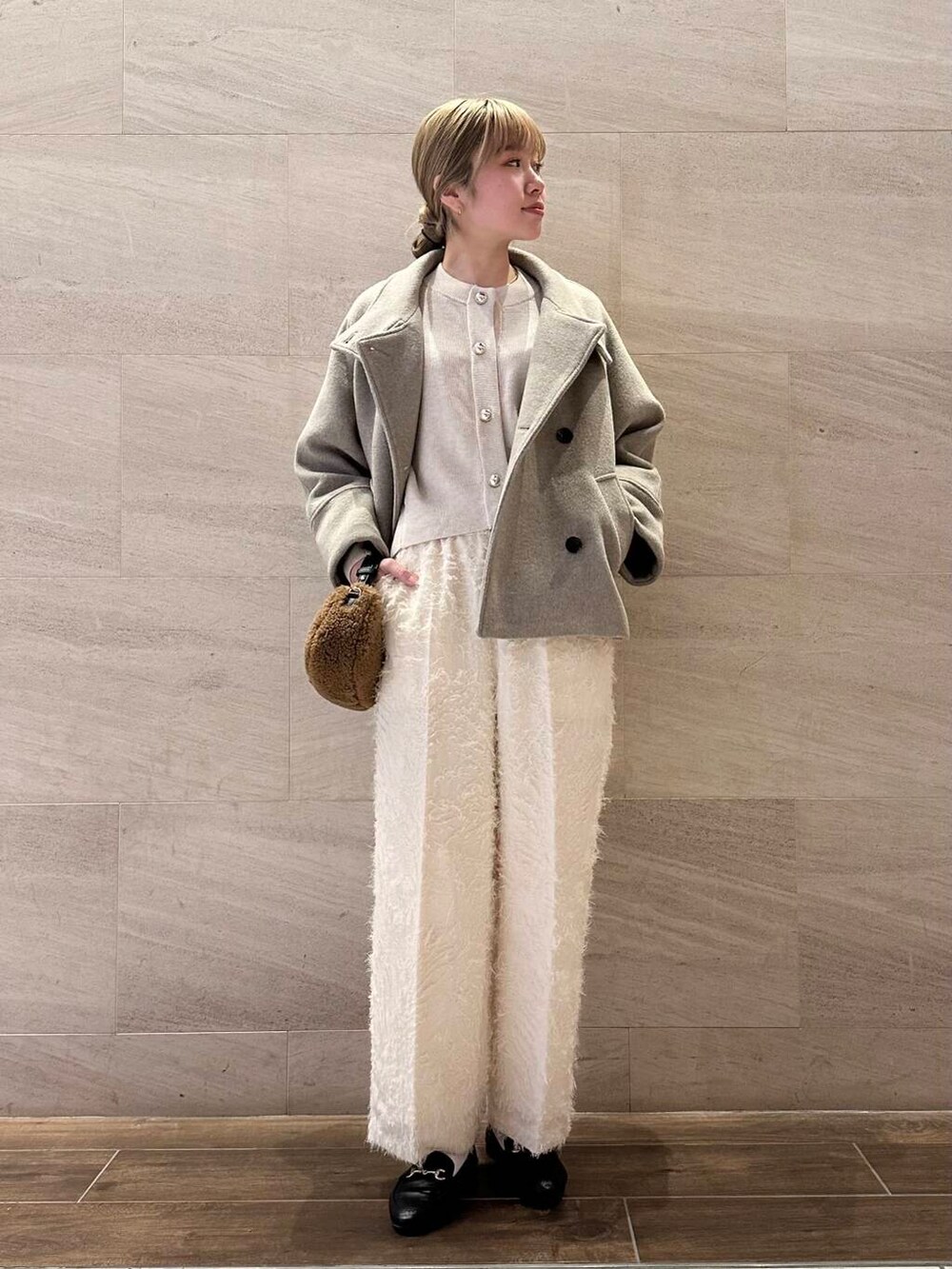 ブラウン系のピーコート、ホワイト系のその他パンツ、ホワイト系のカーディガン/ボレロを着用したレディースの冬コーディネートの3枚目の写真