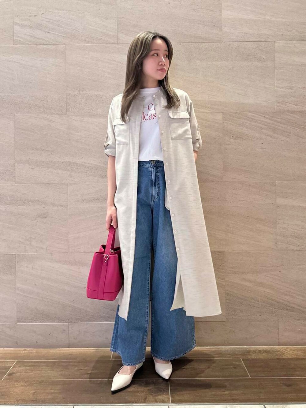 ベージュ系のワンピース、ピンク系のハンドバッグ、ホワイト系のTシャツ/カットソーを着用したレディースの春コーディネートの2枚目の写真