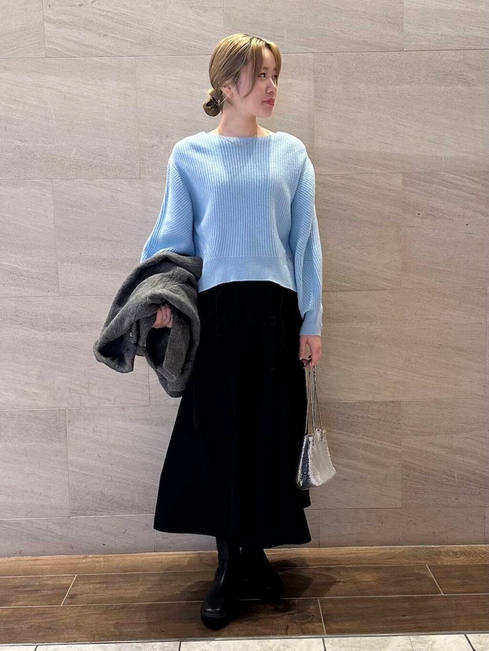 ブラック系のブーツ、グレー系のその他アウター、ブルー系のニット/セーターを着用したレディースの冬コーディネートの3枚目の写真
