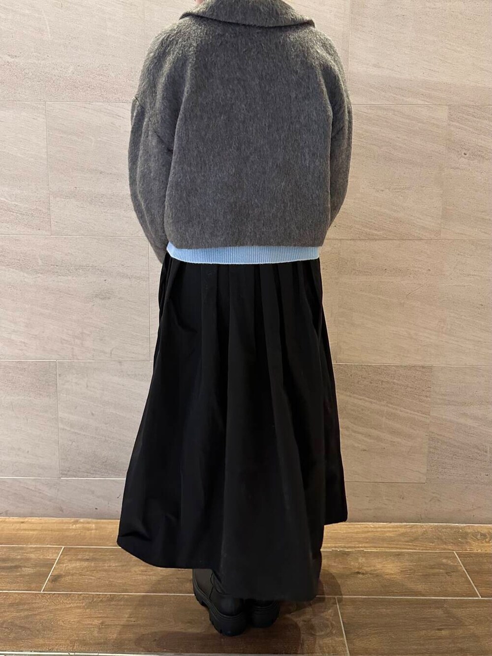 ブラック系のブーツ、グレー系のその他アウター、ブルー系のニット/セーターを着用したレディースの冬コーディネートの6枚目の写真