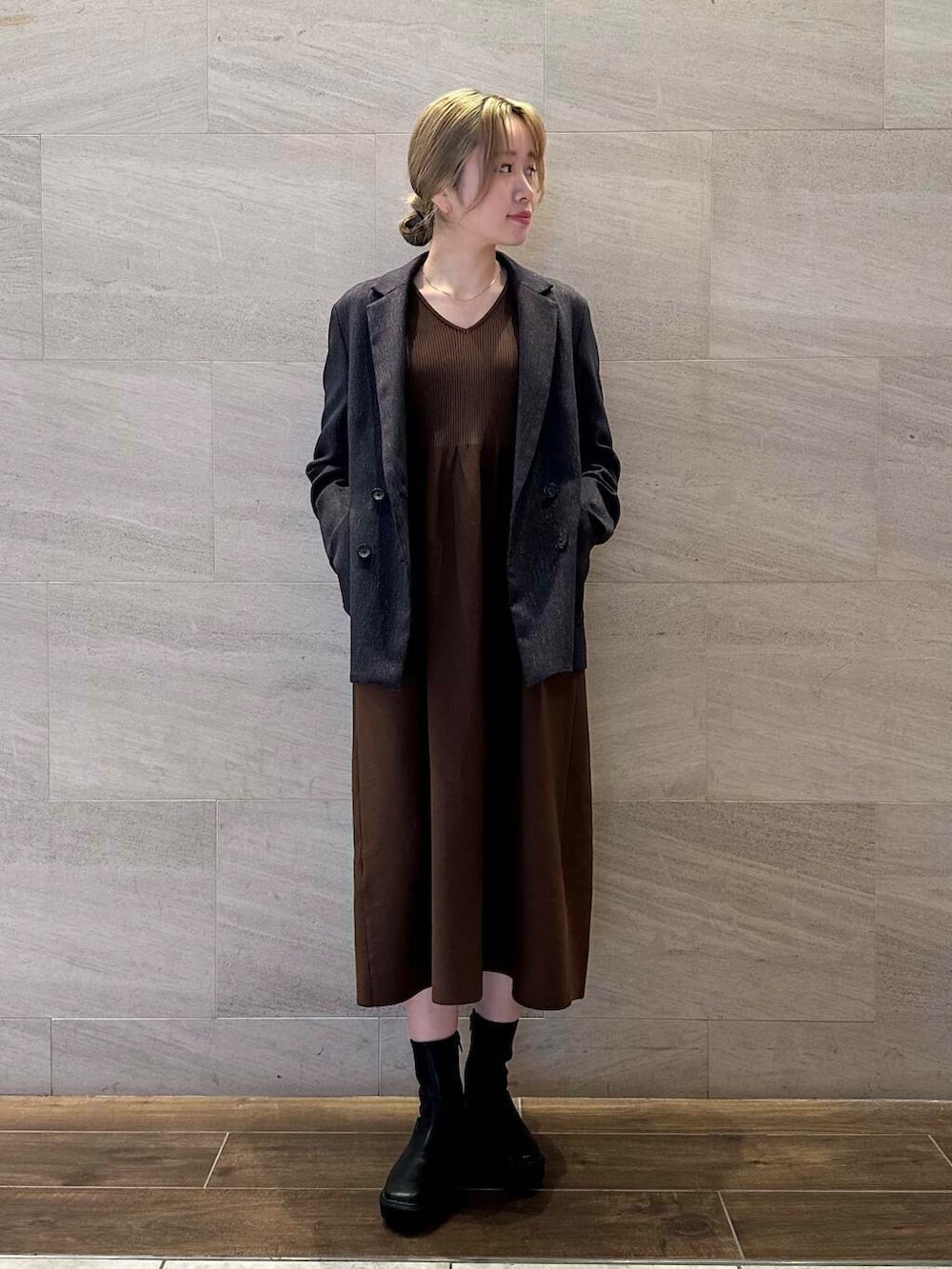 ブラック系のブーツ、ブルー系のその他アウター、ブラウン系のワンピースを着用したレディースの冬コーディネートの2枚目の写真