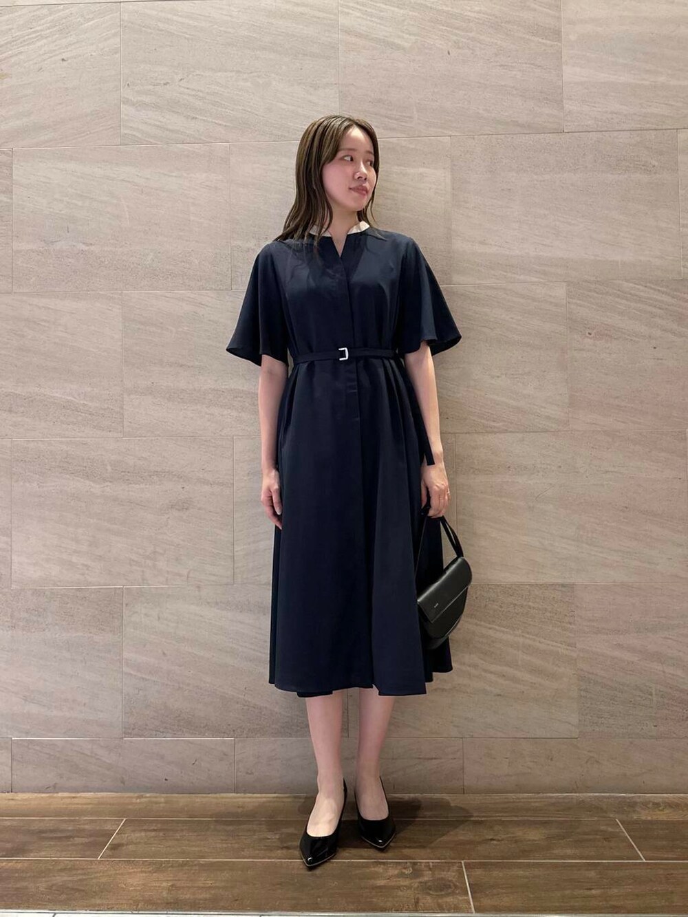 ブラック系のパンプス、ブルー系のワンピース、ブラック系のショルダーバッグを着用したレディースの夏コーディネートの4枚目の写真