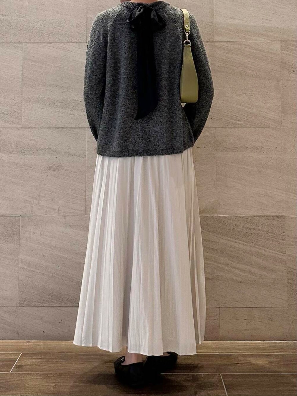 グリーン系のショルダーバッグ、ホワイト系のスカート、グレー系のニット/セーターを着用したレディースの冬コーディネートの5枚目の写真