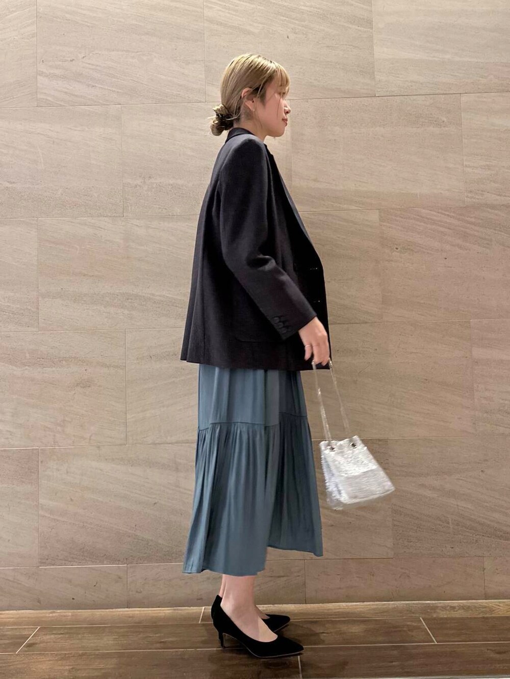 ブラック系のパンプス、ブルー系のワンピース、シルバー系のショルダーバッグを着用したレディースの冬コーディネートの2枚目の写真