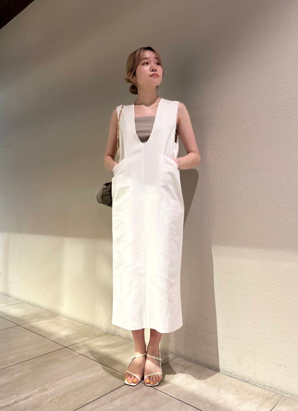 ホワイト系のサンダル、ホワイト系のワンピース、ベージュ系のキャミソールを着用したレディースの夏コーディネートの3枚目の写真