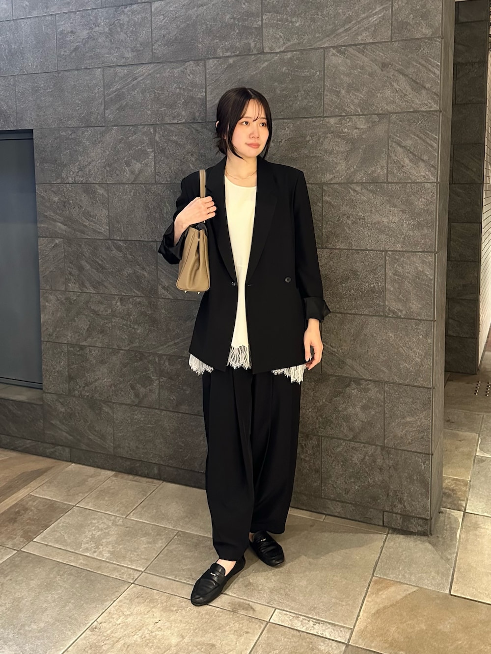 ベージュ系のハンドバッグ、ブラック系のその他パンツ、ホワイト系のタンクトップを着用したレディースの春コーディネートの4枚目の写真