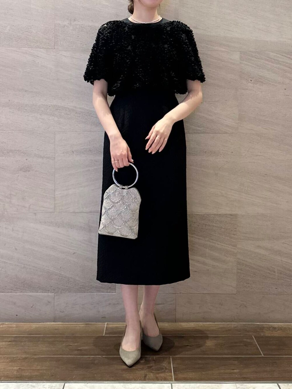 ベージュ系のハンドバッグ、ホワイト系のネックレスを着用したレディースの春コーディネートの5枚目の写真