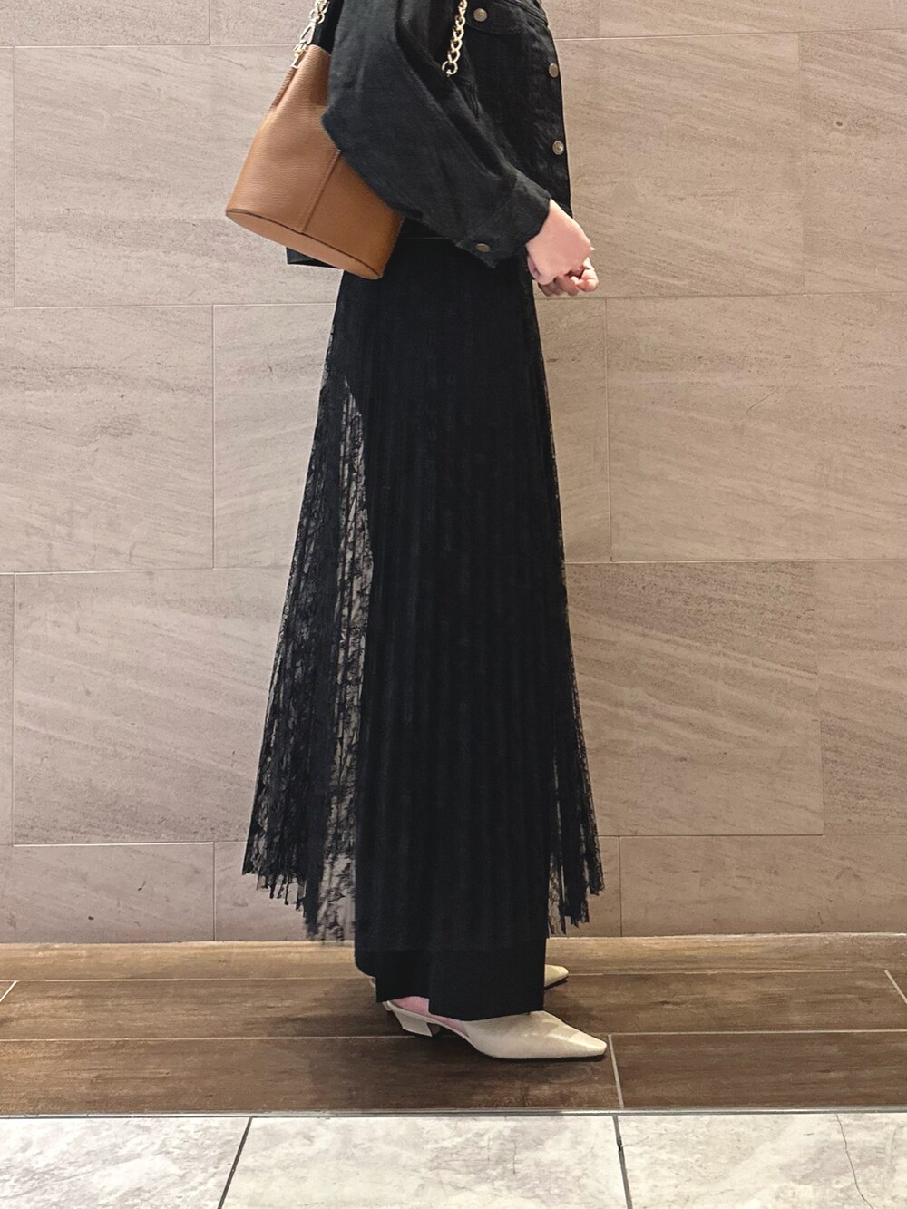 ブラック系のデニムジャケット、ホワイト系のTシャツ/カットソー、ブラック系のスカートを着用したレディースの秋コーディネートの4枚目の写真