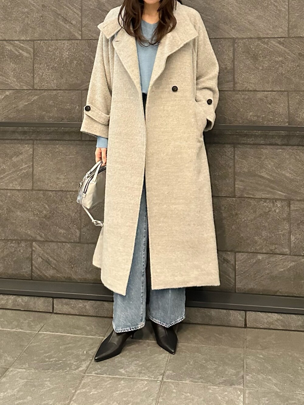 グレー系のその他アウター、ブルー系のニット/セーター、ブルー系のデニムパンツを着用したレディースの冬コーディネートの2枚目の写真