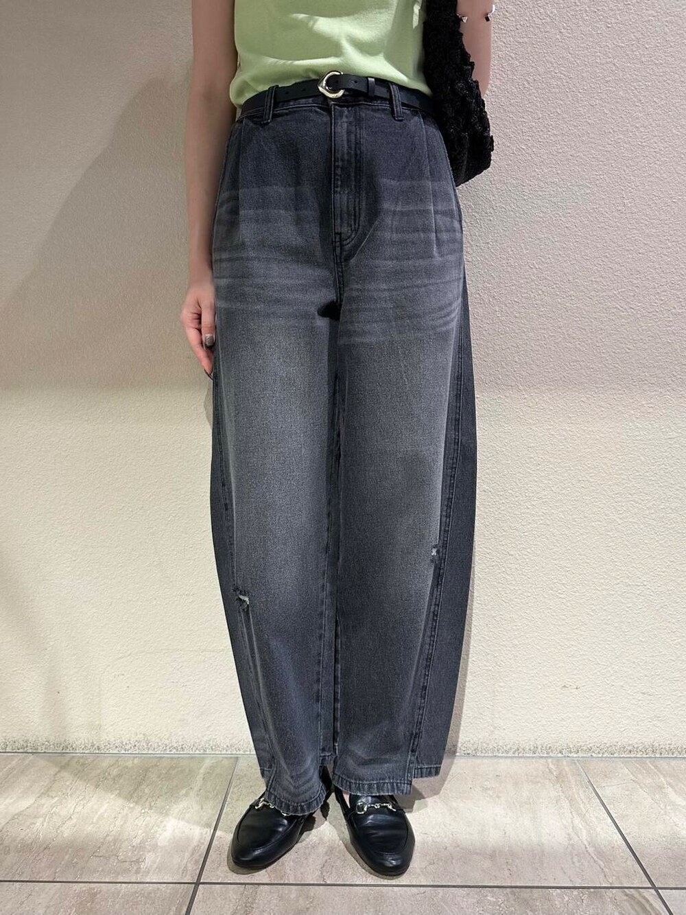 ブラック系のローファー、グリーン系のニット/セーター、グレー系のデニムパンツを着用したレディースの夏コーディネートの4枚目の写真