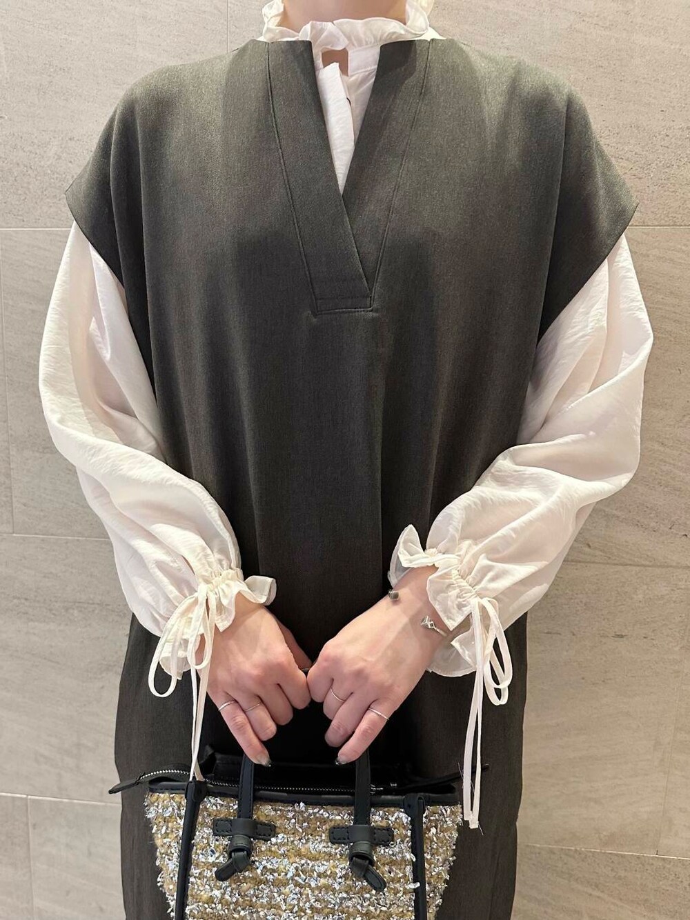 グレー系のパンプス、ホワイト系のシャツ/ブラウス、ブラウン系のワンピースを着用したレディースの秋コーディネートの6枚目の写真