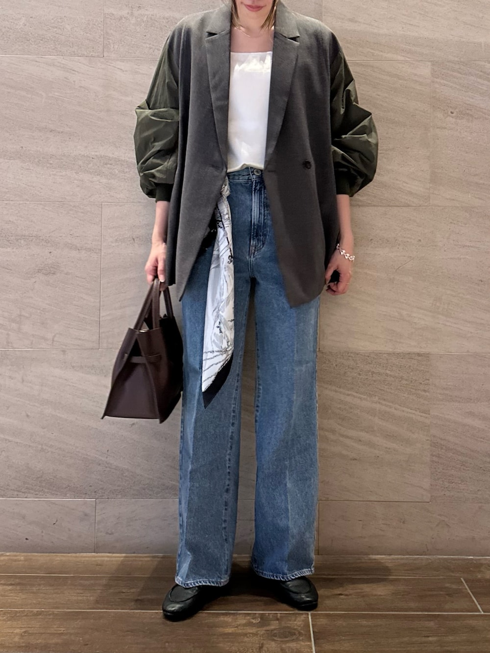 グレー系のその他アウター、ホワイト系のその他トップス、ブルー系のデニムパンツを着用したレディースの秋コーディネートの3枚目の写真