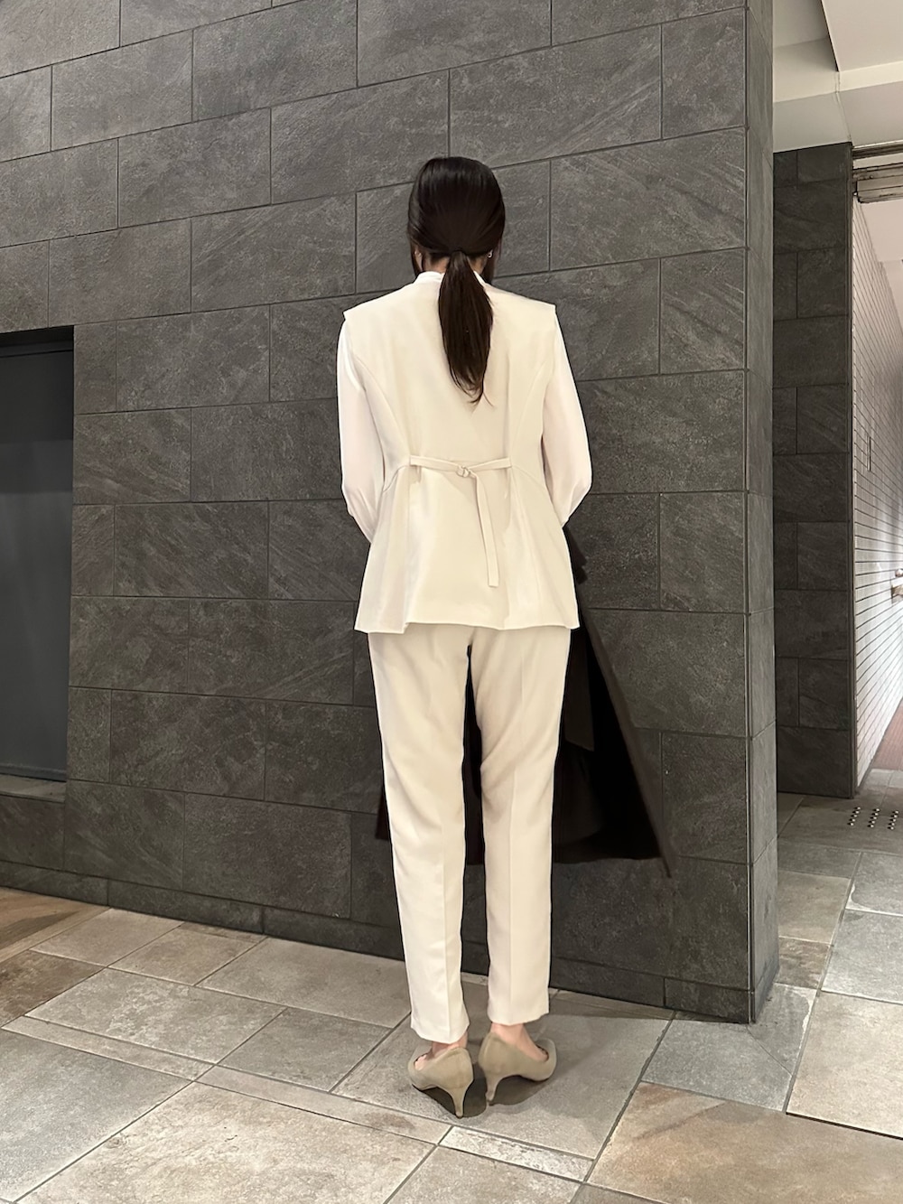 ホワイト系のセットアップ、ベージュ系のトートバッグ、ブラウン系のその他アウターを着用したレディースの冬コーディネートの3枚目の写真