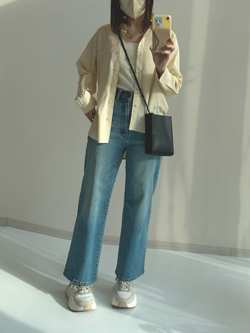 ブルー系のパンツ、ベージュ系のシャツ/ブラウスを着用したレディースの春コーディネートの2枚目の写真