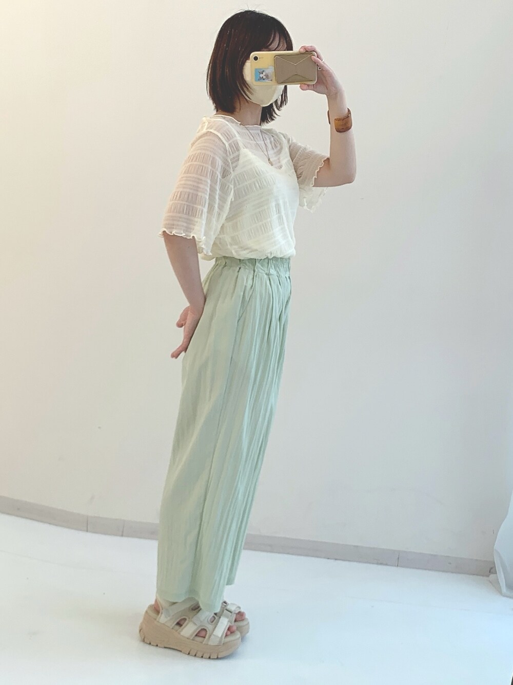 ホワイト系のシャツ/ブラウス、グリーン系のパンツ、ブラック系のサンダルを着用したレディースの春コーディネートの3枚目の写真