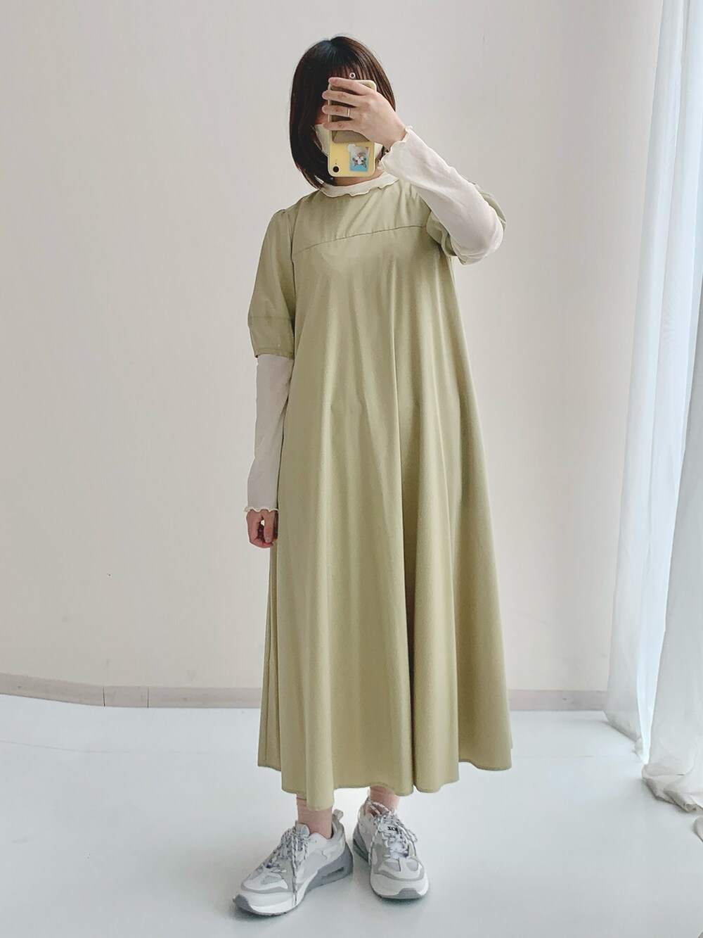 ホワイト系のTシャツ/カットソー、グリーン系のワンピース、グレー系のスニーカーを着用したレディースの春コーディネートの4枚目の写真