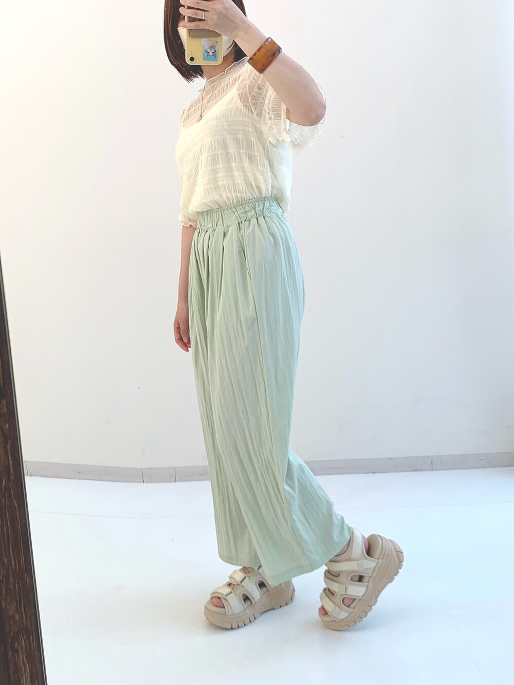 ホワイト系のシャツ/ブラウス、グリーン系のパンツ、ブラック系のサンダルを着用したレディースの春コーディネートの2枚目の写真