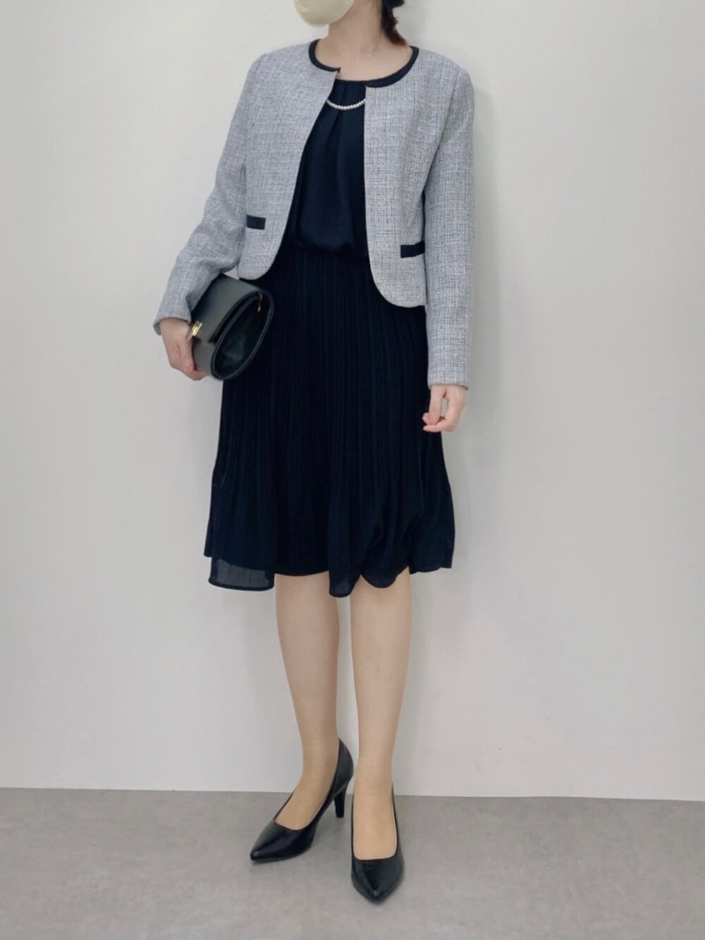 ブルー系のスーツセット、ブラウン系のキャミソールを着用したレディースの冬コーディネートの2枚目の写真