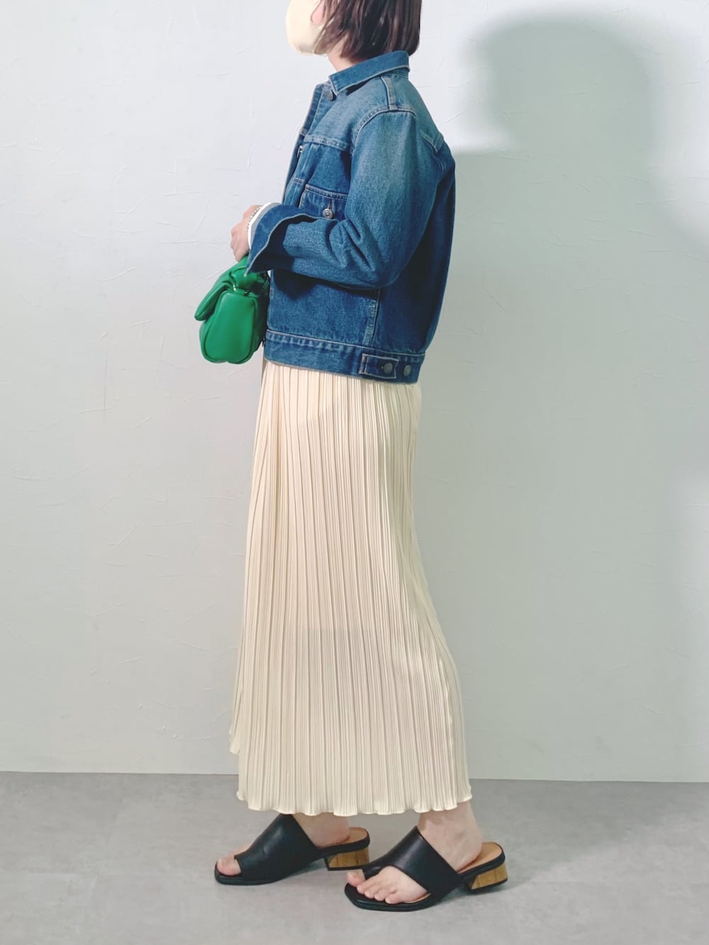 ブルー系のデニムジャケット、ホワイト系のスカートを着用したレディースの春コーディネートの2枚目の写真