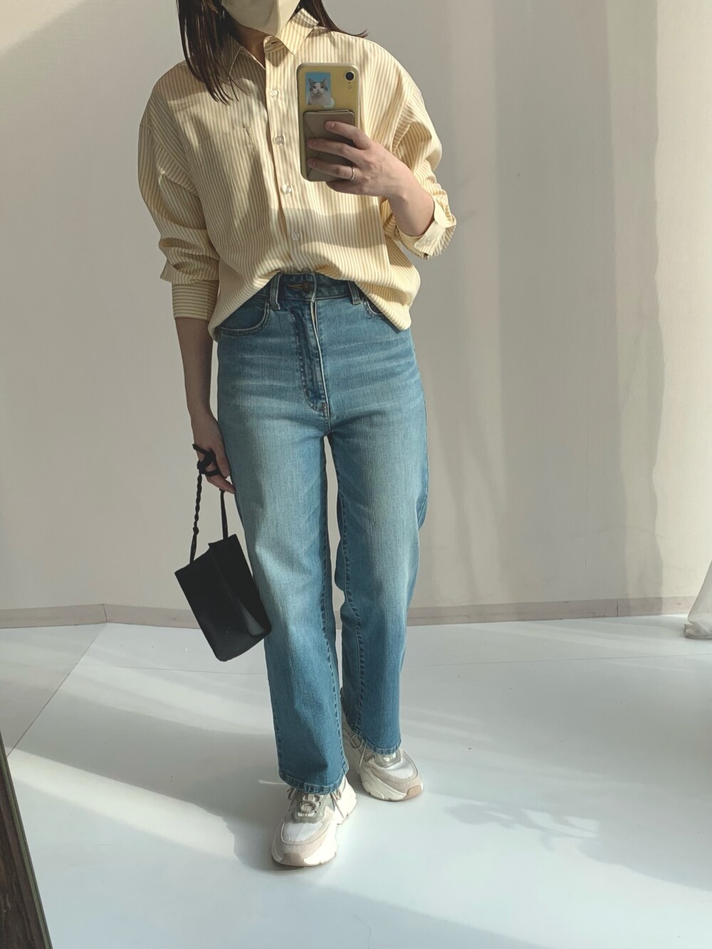 ブルー系のパンツ、ベージュ系のシャツ/ブラウスを着用したレディースの春コーディネートの3枚目の写真