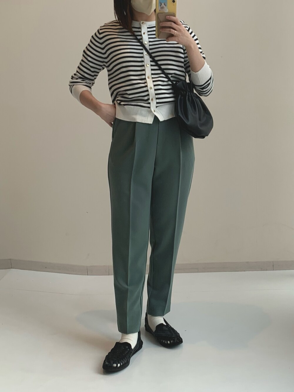 ホワイト系のカーディガン/ボレロ、グリーン系のパンツを着用したレディースの春コーディネートの2枚目の写真