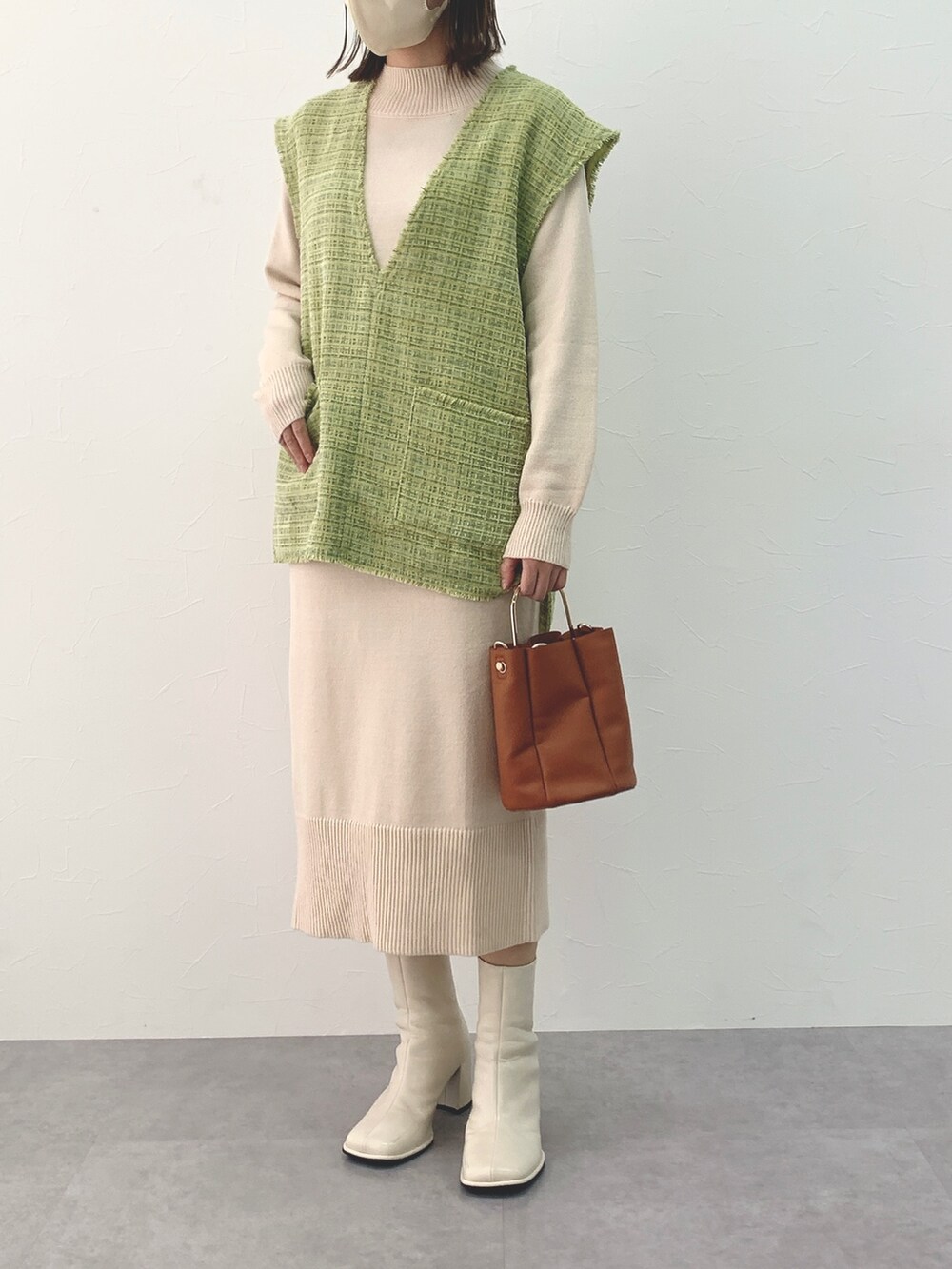 グリーン系のジャケット/アウター、ホワイト系のワンピースを着用したレディースの冬コーディネートの2枚目の写真