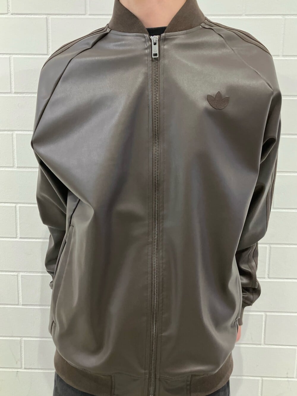 ホワイト系のスニーカー、ブラウン系のジャージ、ブラック系のデニムパンツを着用したメンズの冬コーディネートの4枚目の写真