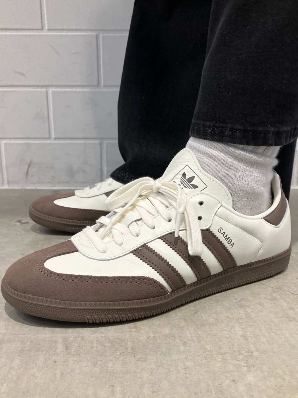 ホワイト系のスニーカー、ブラウン系のジャージ、ブラック系のデニムパンツを着用したメンズの冬コーディネートの6枚目の写真