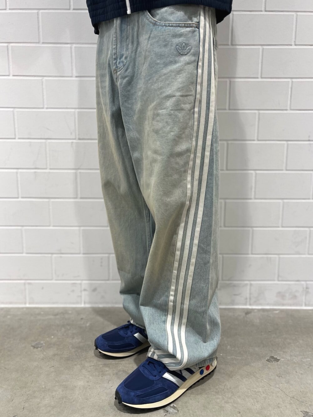 ブルー系のナイロンジャケット、ブルー系のデニムパンツ、ブルー系のシューズを着用したメンズの秋コーディネートの5枚目の写真