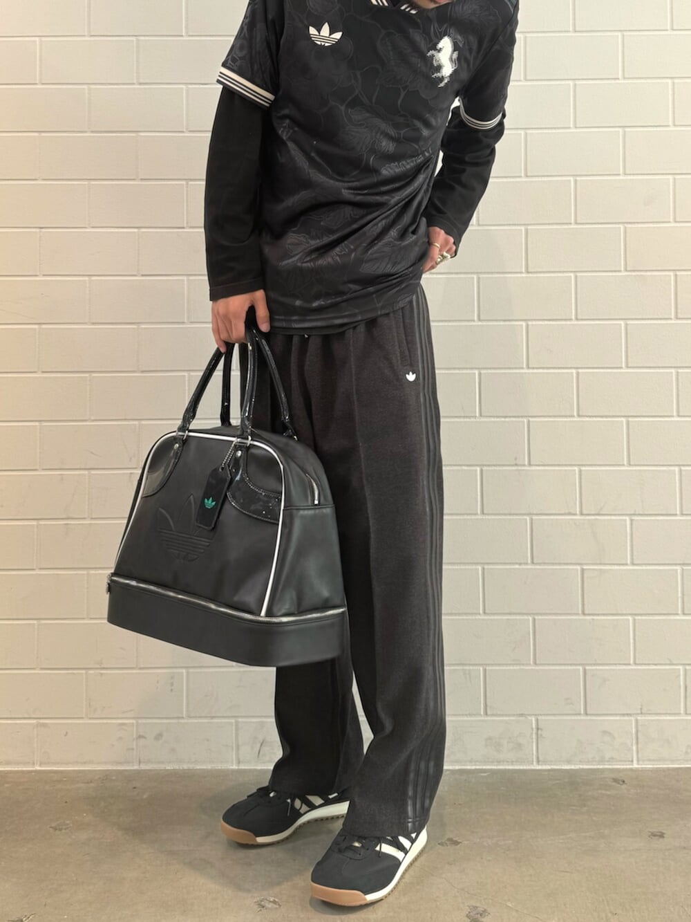 ブラック系のショルダーバッグ、ブラック系のTシャツ/カットソー、ブラック系のスウェットパンツを着用したメンズの秋コーディネートの2枚目の写真