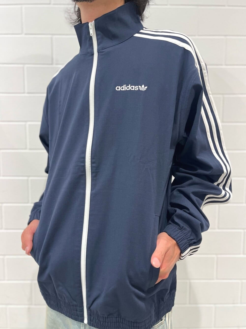 ブルー系のナイロンジャケット、ブルー系のデニムパンツ、ブルー系のシューズを着用したメンズの秋コーディネートの4枚目の写真