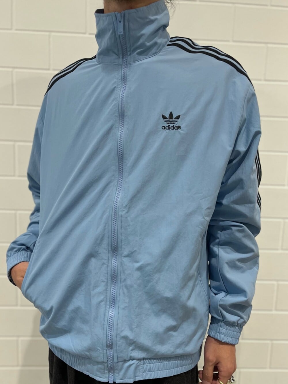 ブルー系のナイロンジャケット、ブルー系のスニーカーを着用したメンズの秋コーディネートの4枚目の写真