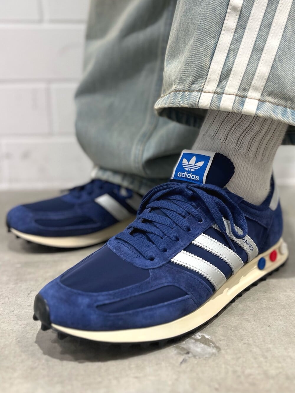 ブルー系のナイロンジャケット、ブルー系のデニムパンツ、ブルー系のシューズを着用したメンズの秋コーディネートの6枚目の写真