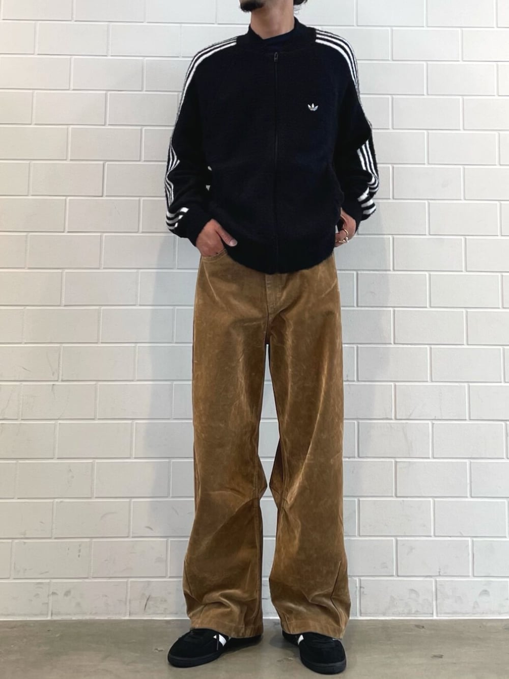 ブラック系のスニーカー、ブラック系のジャージ、ブラウン系のその他パンツを着用したメンズの秋コーディネートの2枚目の写真