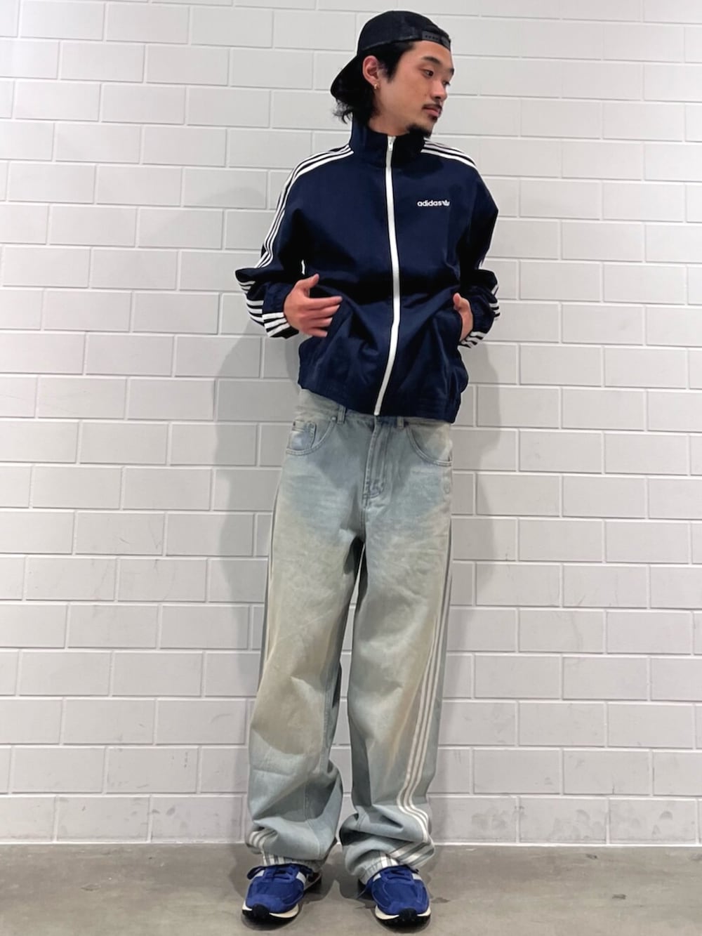 ブルー系のナイロンジャケット、ブルー系のデニムパンツ、ブルー系のシューズを着用したメンズの秋コーディネートの3枚目の写真