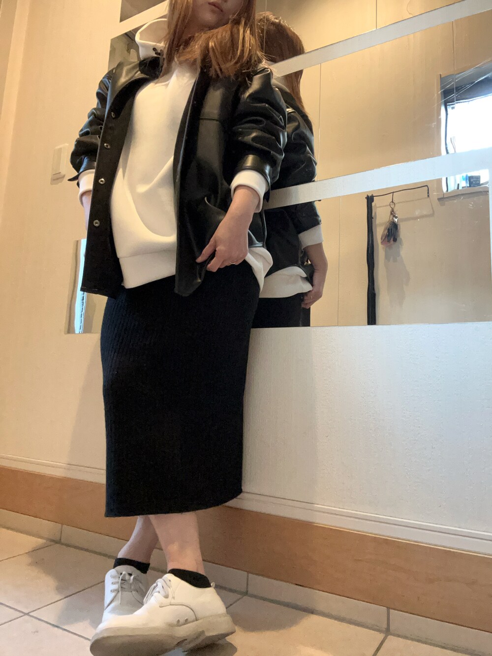 ホワイト系のパーカー、ブラック系のシャツ/ブラウス、ブラック系のスカートを着用したレディースの春コーディネートの2枚目の写真