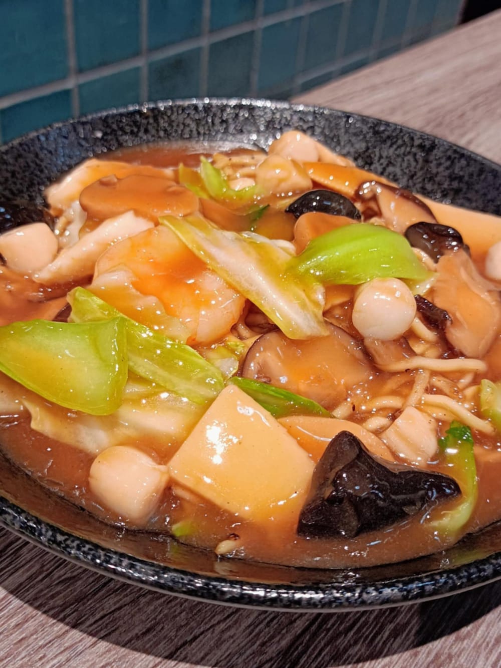 グリーン系のパンツ、ブルー系のマウンテンパーカー、グレー系のスニーカーを着用したメンズの秋コーディネートの5枚目の写真