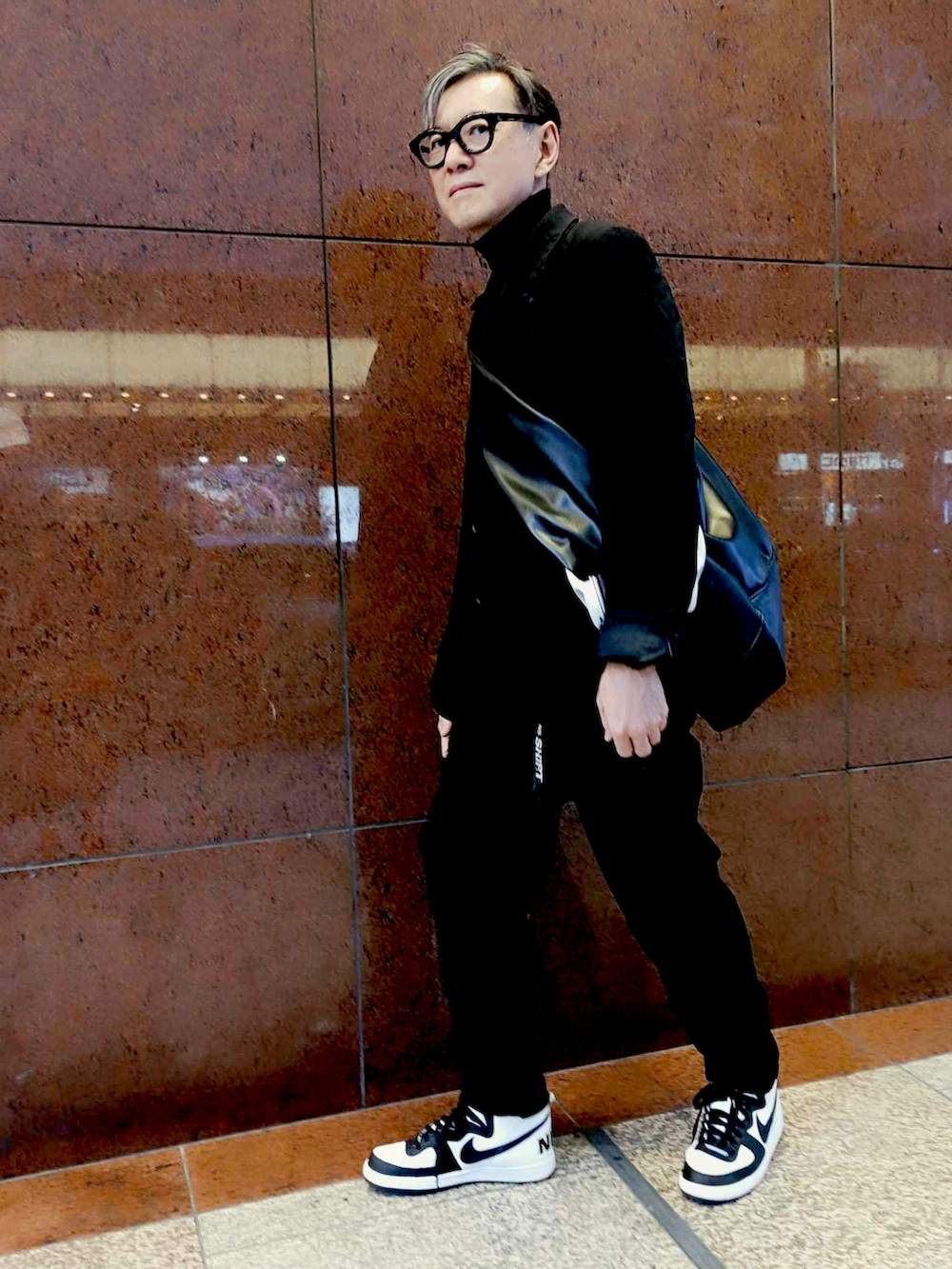 ブラック系のニット/セーター、ブラック系のセットアップ、ブラック系のスニーカーを着用したメンズの冬コーディネートの2枚目の写真