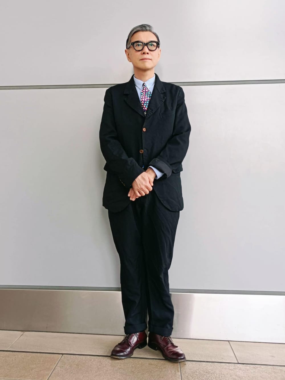 ブラック系のテーラードジャケット、ブルー系のシャツ/ブラウス、ブラック系のパンツを着用したメンズの冬コーディネートの2枚目の写真