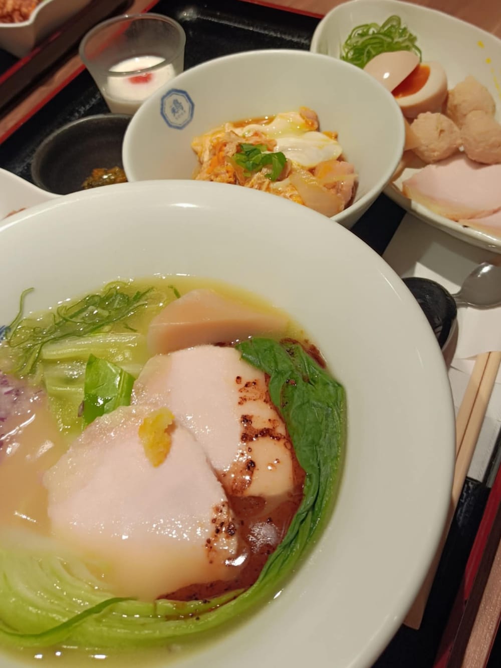 ホワイト系のスニーカー、ブラック系のポンチョ、ホワイト系のTシャツ/カットソーを着用したメンズの春コーディネートの5枚目の写真