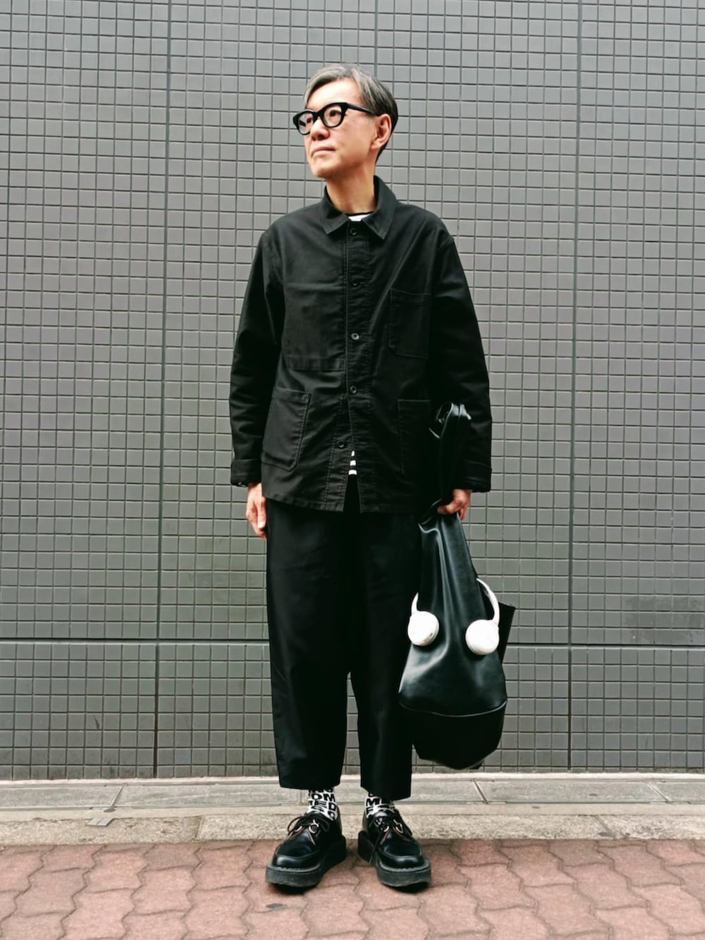 ブラック系のカバーオール、ブラック系のパンツ、ブラック系のドレスシューズを着用したメンズの冬コーディネートの3枚目の写真