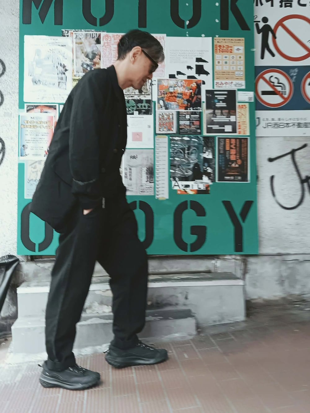 ブラック系のセットアップ、ブラック系のTシャツ/カットソー、ブラック系のスニーカーを着用したメンズの春コーディネートの2枚目の写真