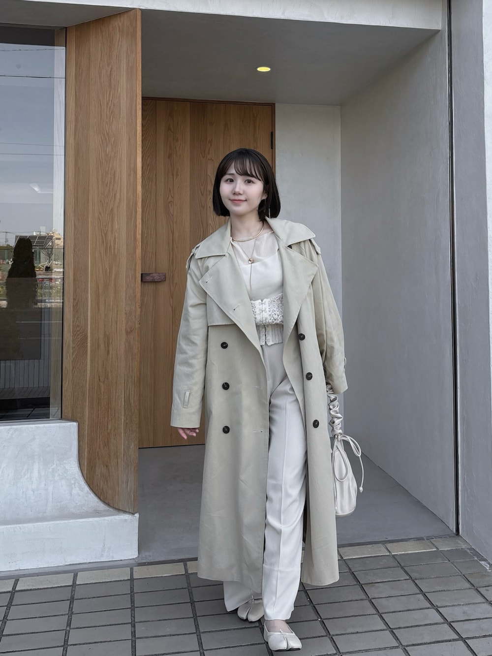 ホワイト系のニット/セーター、ホワイト系のバッグ、ホワイト系のパンプスを着用したレディースの秋コーディネートの2枚目の写真