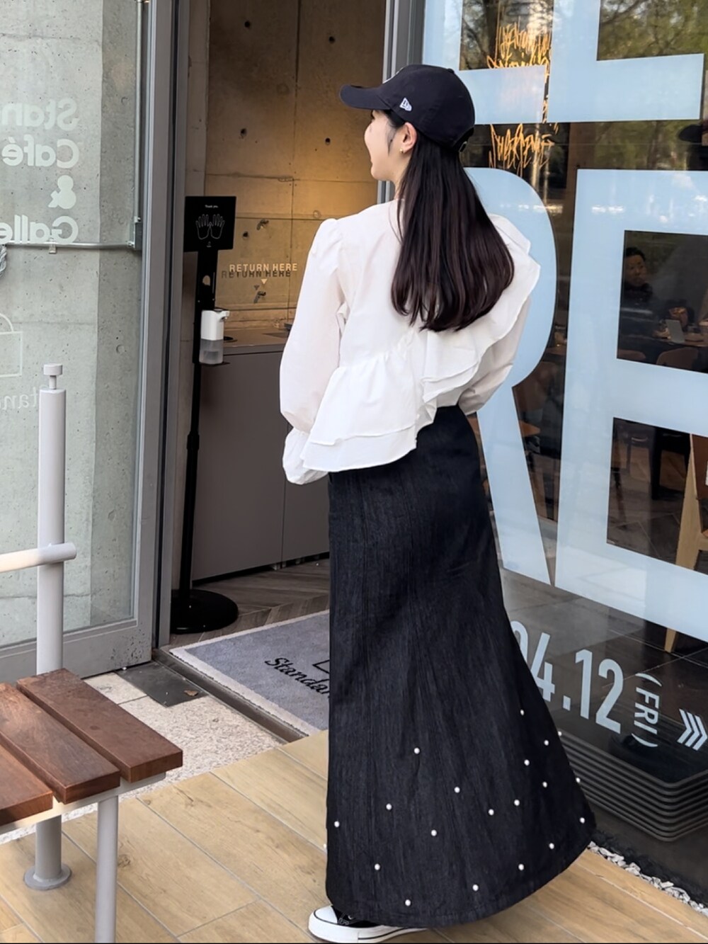 ホワイト系のシャツ/ブラウス、ブラック系のデニムスカート、ブラック系のスニーカーを着用したレディースの春コーディネートの2枚目の写真