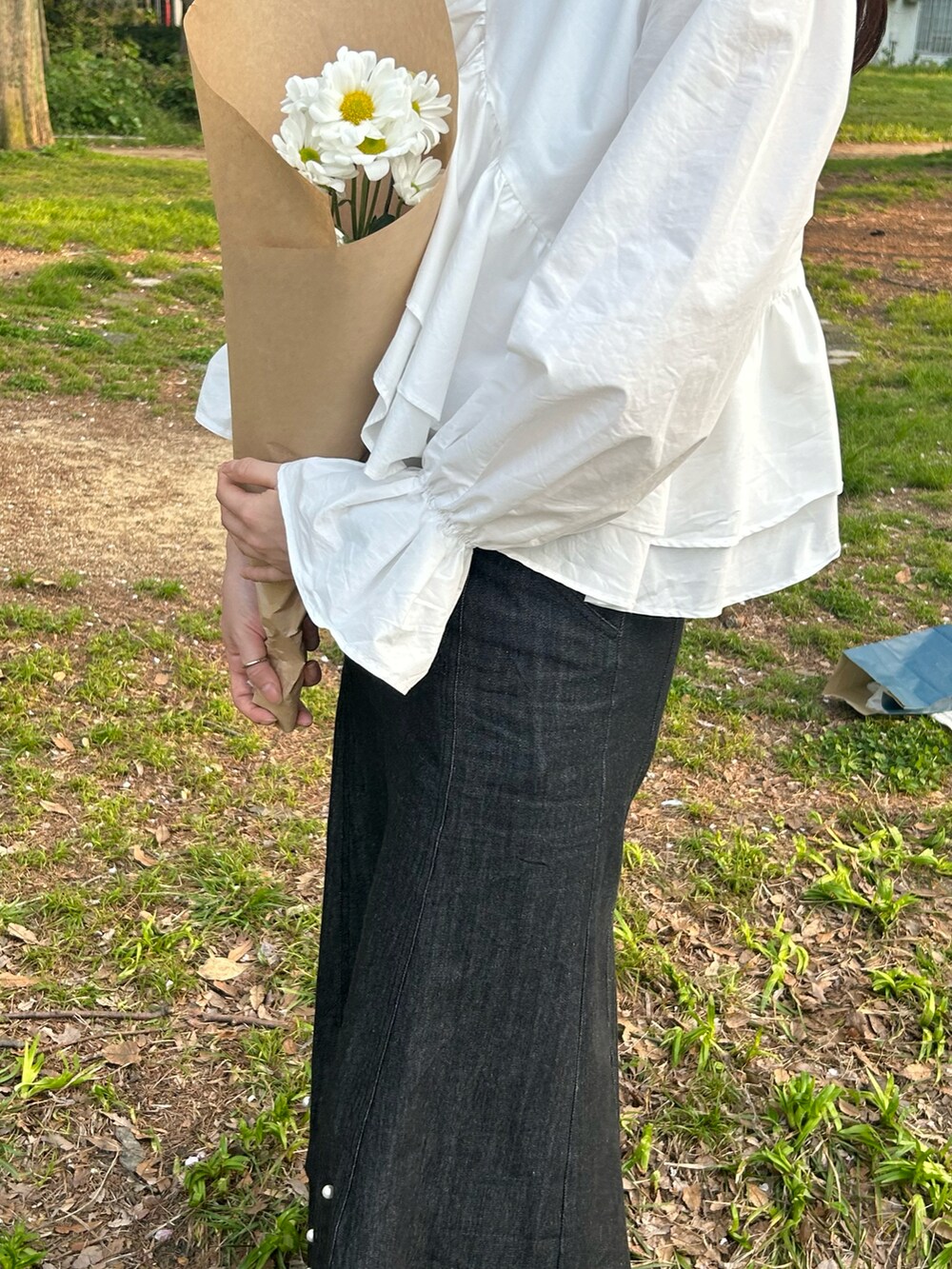 ホワイト系のシャツ/ブラウス、ブラック系のデニムスカート、ブラック系のスニーカーを着用したレディースの春コーディネートの3枚目の写真